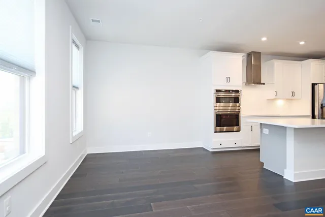 a view of kitchen with wooden floor and electronic appliances