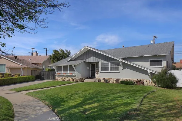 a front view of a house with a garden and yard