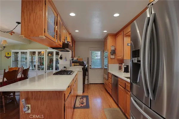 a kitchen with stainless steel appliances granite countertop a refrigerator a stove and a wooden floors