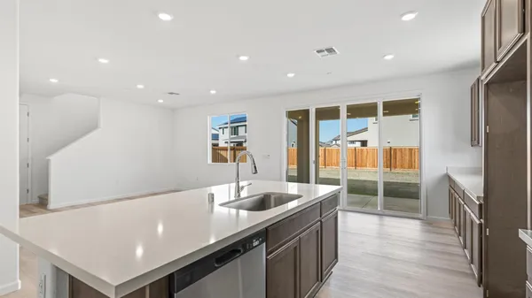 a kitchen with stainless steel appliances granite countertop a sink a stove and a refrigerator