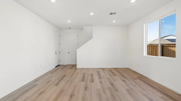 a view of a room with wooden floor and white walls