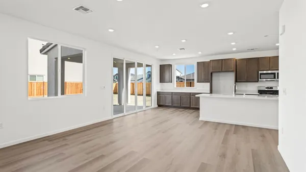 a view of kitchen with cabinets stainless steel appliances wooden floor and window