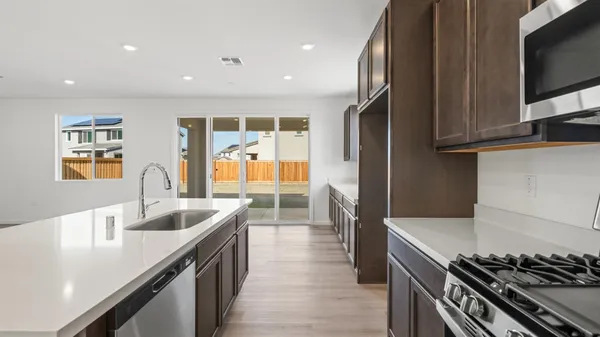 a kitchen with granite countertop a sink stainless steel appliances and cabinets