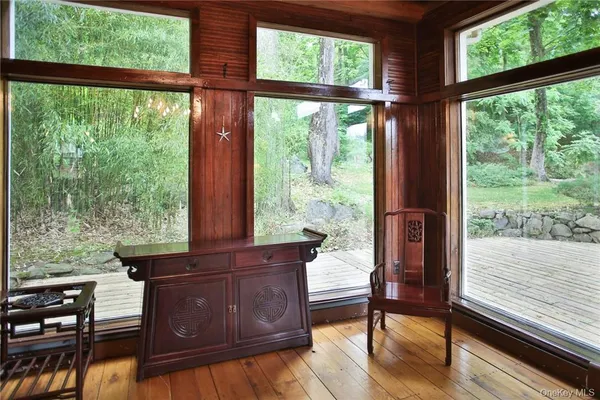 a view of a room with two large windows and wooden floor