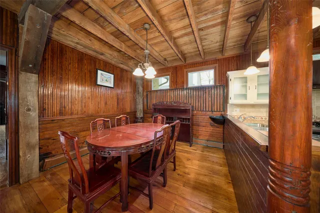 a view of a room with two large windows and wooden floor