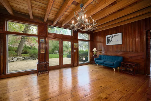 a living room with hardwood floor and large windows