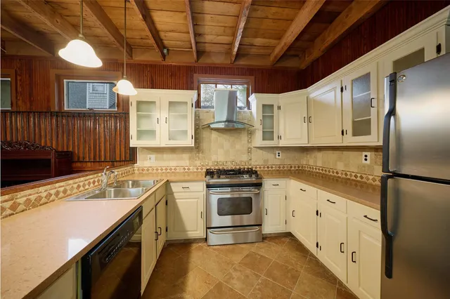 a kitchen with stainless steel appliances granite countertop a refrigerator and a stove