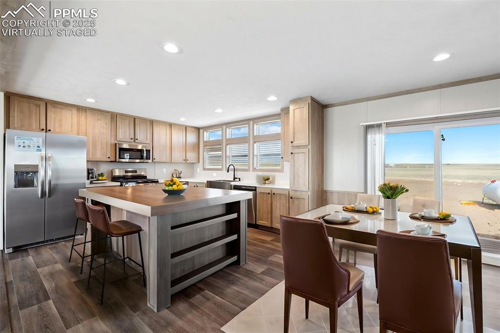 30495 Darroll Drive Yoder, CO 80864 - Photo 6 of 34 a kitchen with granite countertop a stove a sink dishwasher a refrigerator and wooden cabinets with wooden floor