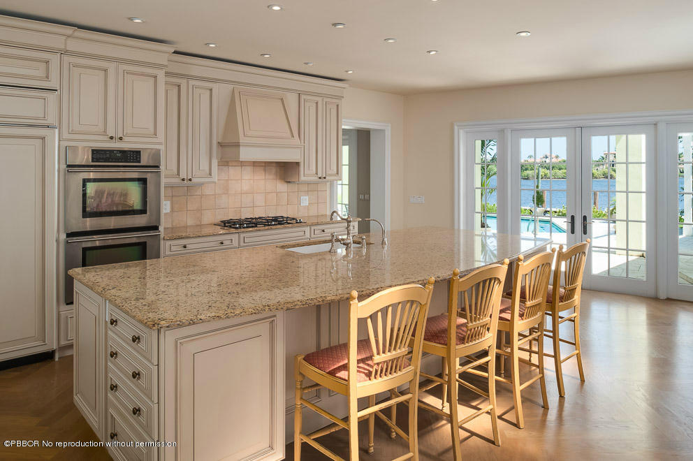 1630 Lands End Road Manalapan, FL 33462 - Photo 5 of 19 a kitchen with stainless steel appliances granite countertop a stove top oven a sink with cabinets and wooden floor