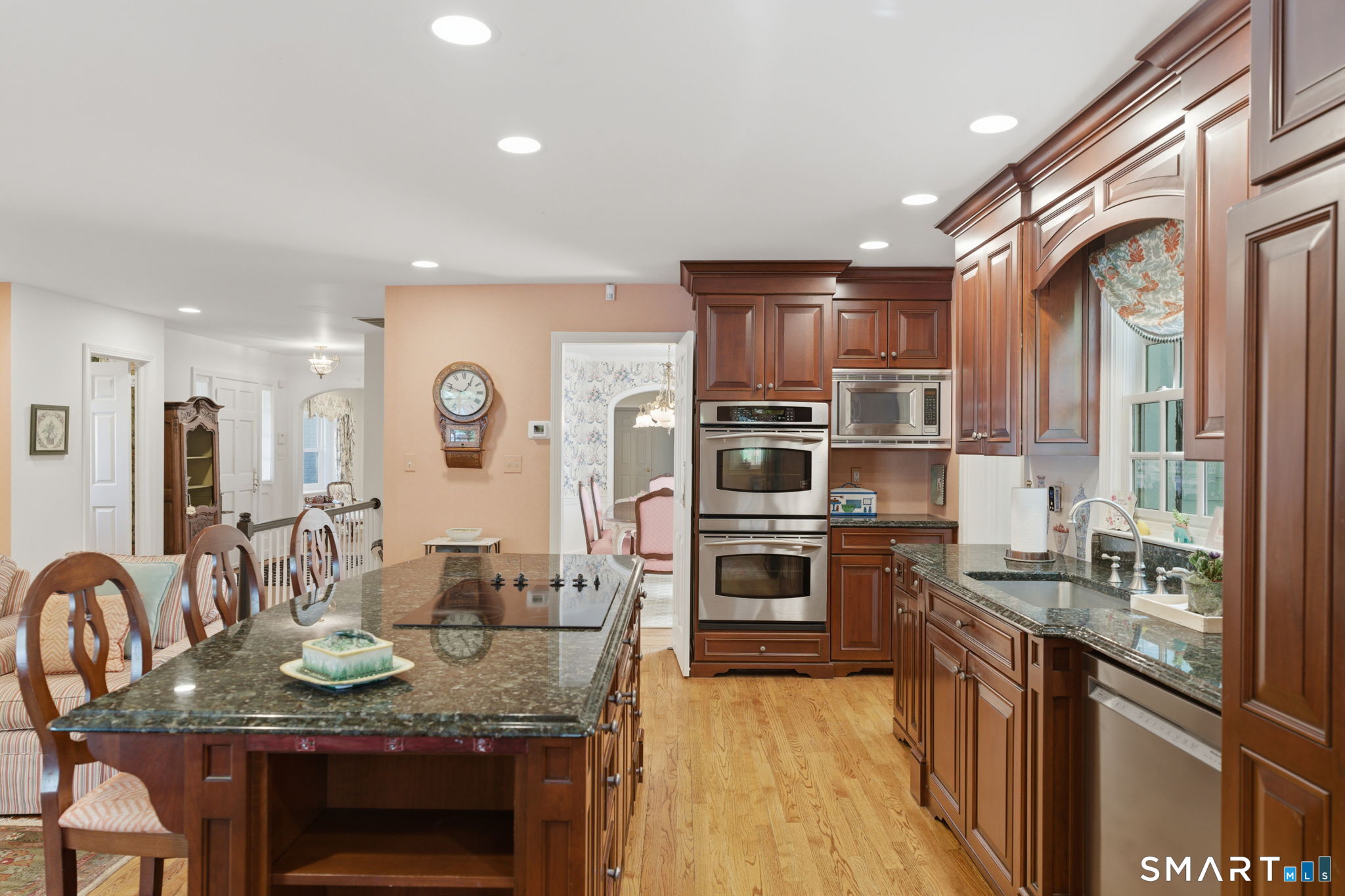 25 Norwood Road West Hartford, CT 06117 - Photo 20 of 40 a kitchen with stainless steel appliances granite countertop a stove top oven a sink dishwasher a dining table and chairs with wooden floor