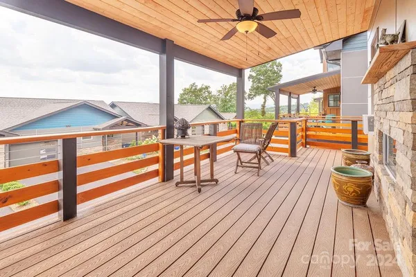 a balcony with wooden floor and outdoor seating