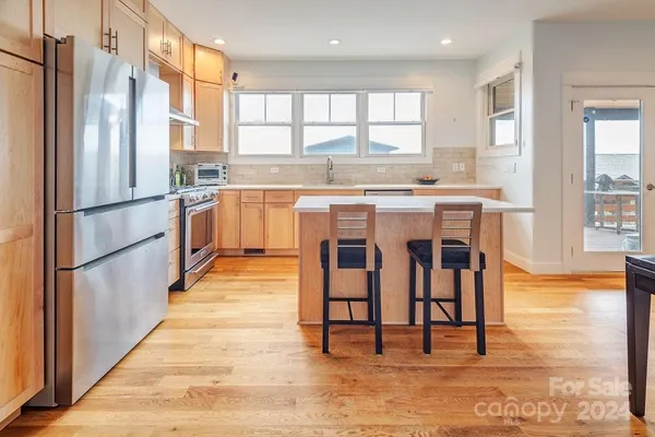 a kitchen with stainless steel appliances granite countertop a refrigerator and a stove top oven