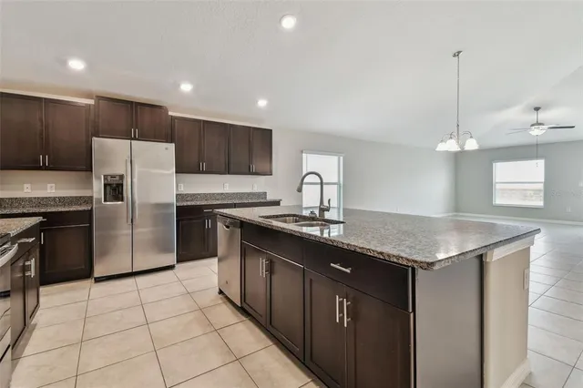 a kitchen with stainless steel appliances granite countertop a refrigerator and a sink