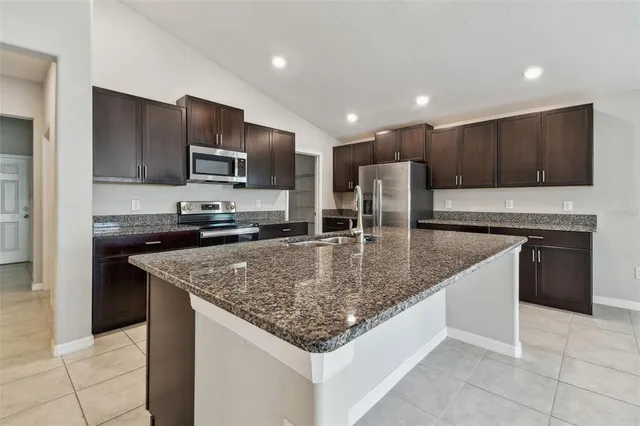 a kitchen with stainless steel appliances granite countertop a sink and a stove