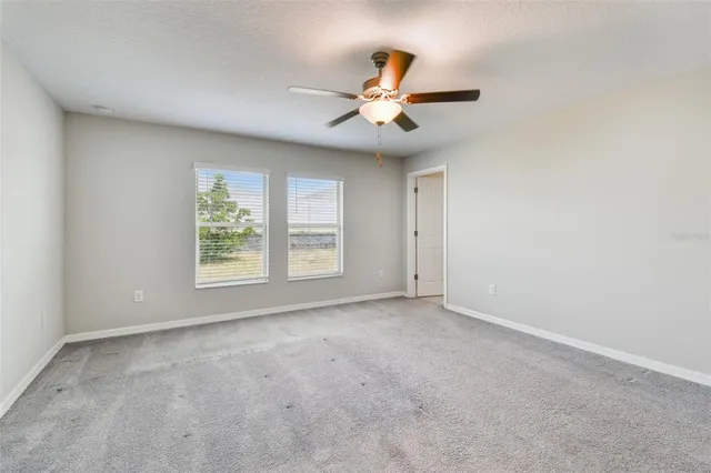 a spacious bathroom with a granite countertop sink toilet and mirror