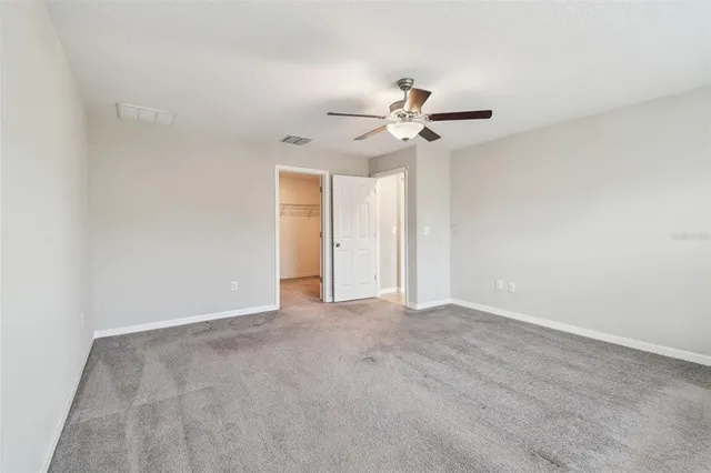 an empty room with a window and a fan