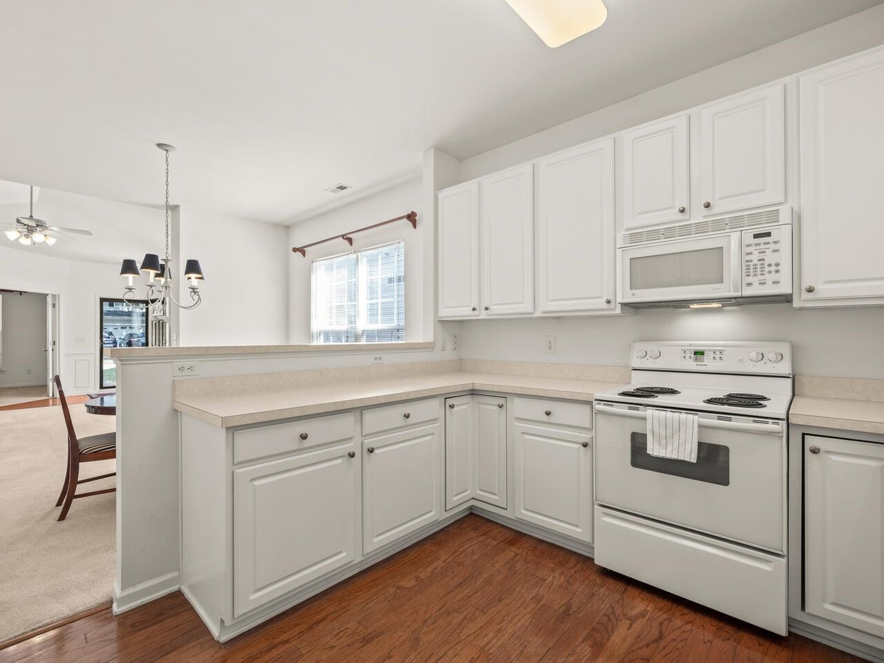 8425 Lunar Stone Place Raleigh, NC 27613 - Photo 9 of 34 a kitchen with granite countertop white cabinets and white appliances