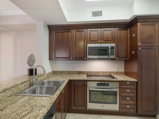 a kitchen with stainless steel appliances a sink and a refrigerator