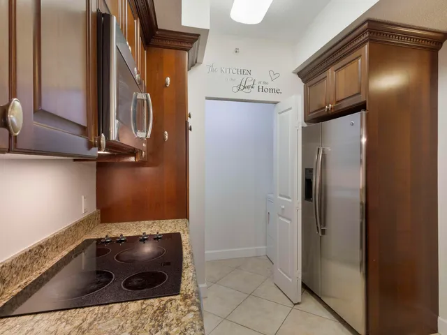a view of a kitchen with wooden floor and a hallway