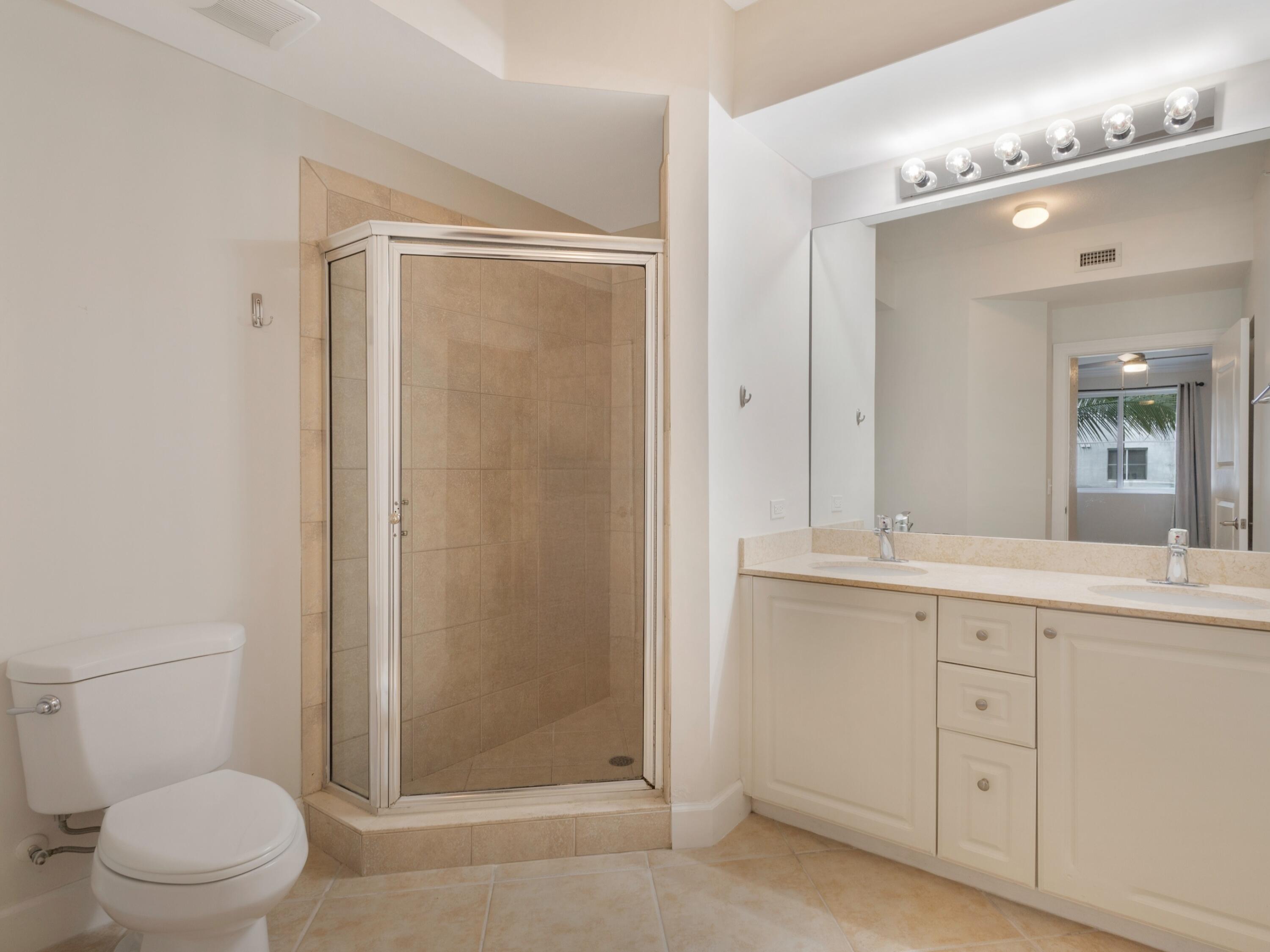 1660 Renaissance Commons Boulevard, Unit 2326 Boynton Beach, FL 33426 - Photo 29 of 59 a bathroom with a granite countertop sink a toilet and a shower