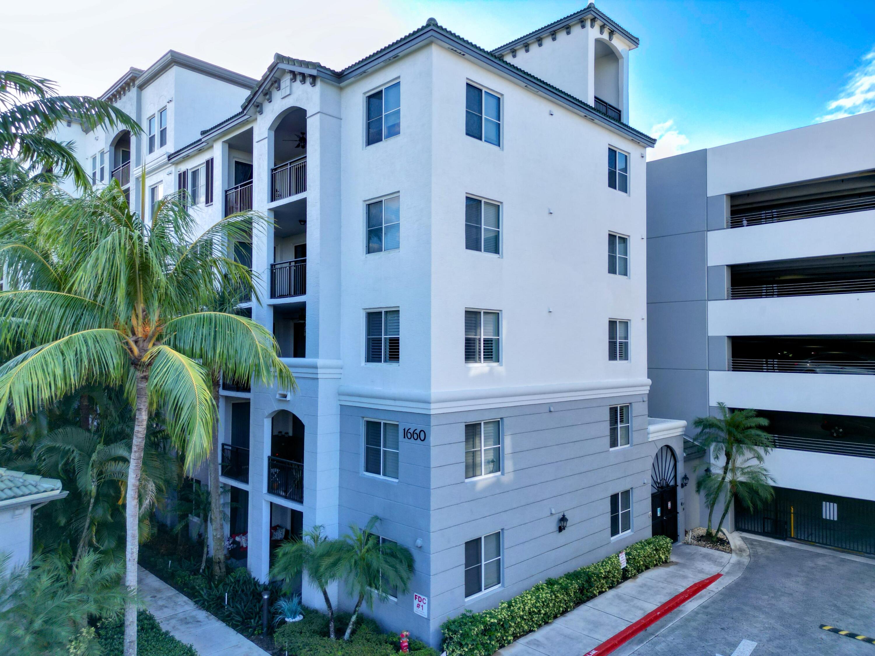 1660 Renaissance Commons Boulevard, Unit 2326 Boynton Beach, FL 33426 - Photo 3 of 59 a large building with a yard and potted plants