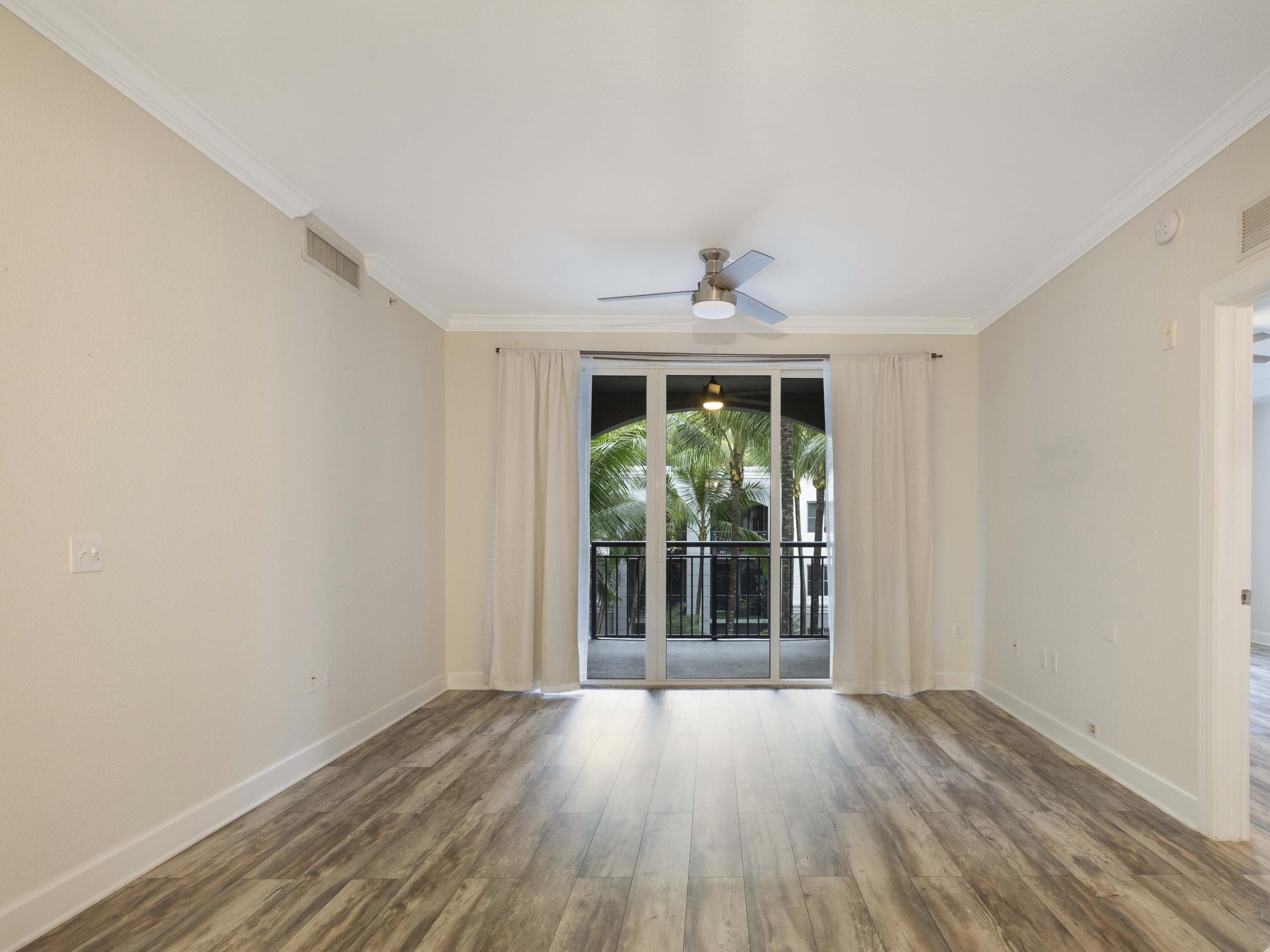 1660 Renaissance Commons Boulevard, Unit 2326 Boynton Beach, FL 33426 - Photo 10 of 59 a view of an empty room with wooden floor and a window