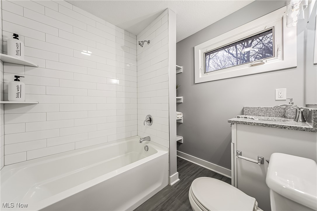 1240 Dorsh Road Cleveland, OH 44121 - Photo 22 of 36 Second floor bathroom featuring toilet, vanity, ceramic tile floors, and washtub / shower combination