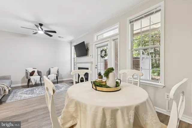 a view of a dining room with furniture a fireplace and wooden floor
