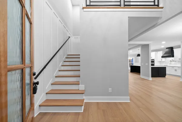 a view of a big room with wooden floor a chandelier fan and windows
