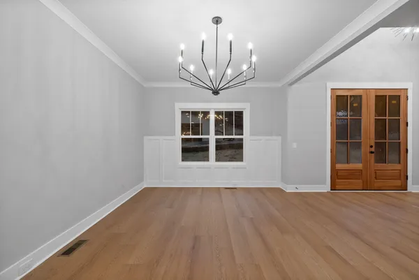 a view of an empty room with wooden floor and a fireplace