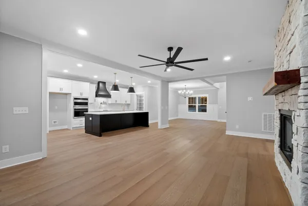 a large kitchen with stainless steel appliances kitchen island granite countertop a large counter top and wooden floors