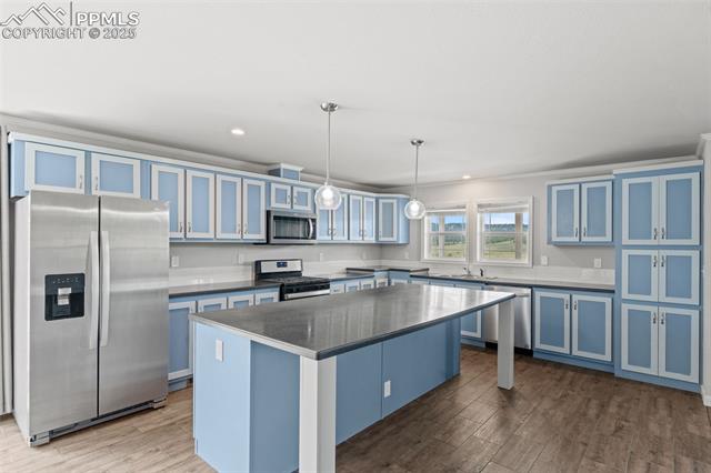 567 High Pasture Road Florissant, CO 80816 - Photo 2 of 48 Kitchen with expamsive cabinetry, stainless steel appliances, ornamental molding, a center island, and solid surface countertops