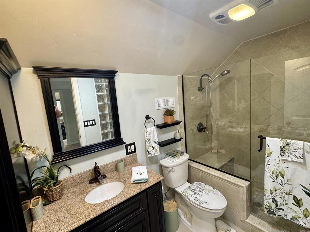 12443 Danes Road Poway, CA 92064 - Photo 22 of 44 a bathroom with a granite countertop sink toilet a mirror a bathtub and shower