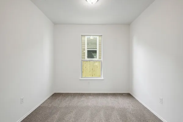 an empty room with a window and a fireplace