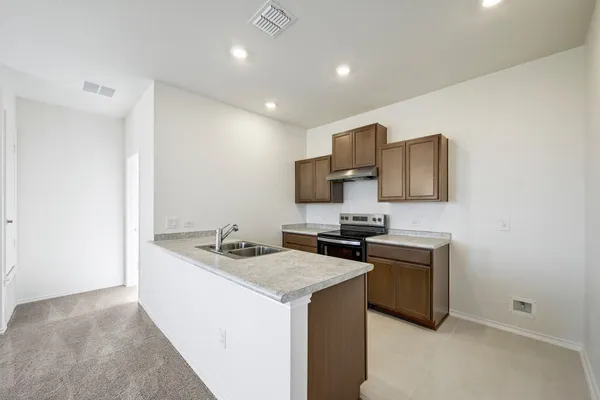 a kitchen with stainless steel appliances granite countertop a sink stove and refrigerator