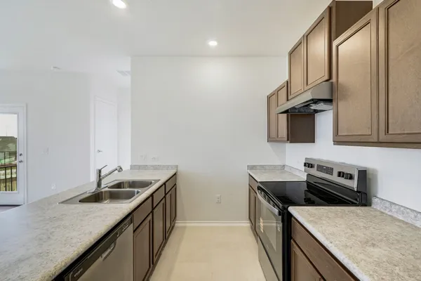 a kitchen with stainless steel appliances granite countertop a sink stove and refrigerator