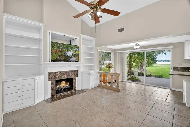 an empty room with fireplace fan and windows
