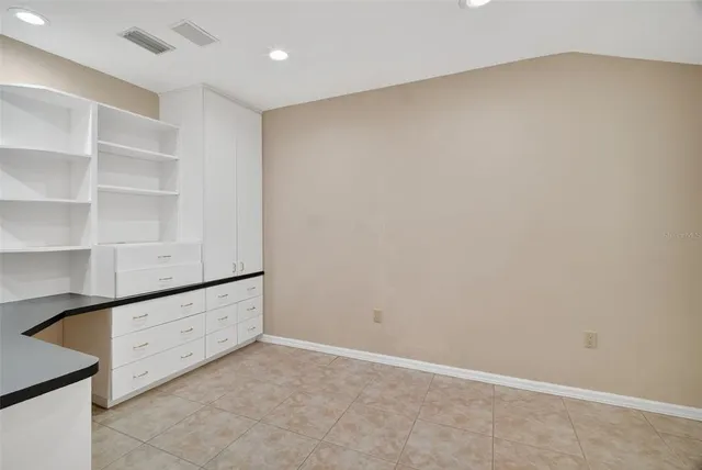 a large white kitchen with a large window and stainless steel appliances