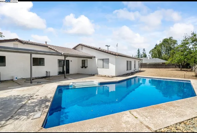 a view of a house with pool and sitting area
