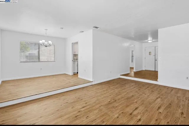 a view of empty room with window and wooden floor