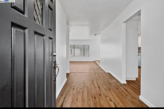 a view of a hallway with wooden floor and staircase