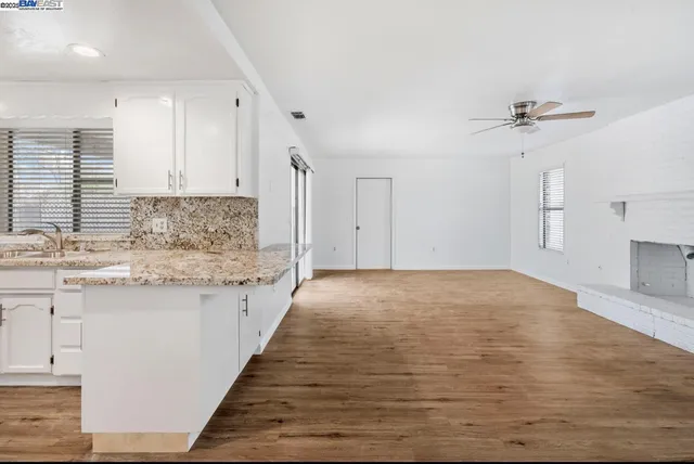 a kitchen with granite countertop a stove sink and cabinets