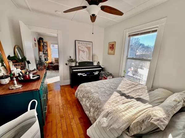 a bedroom with bed and wooden floor