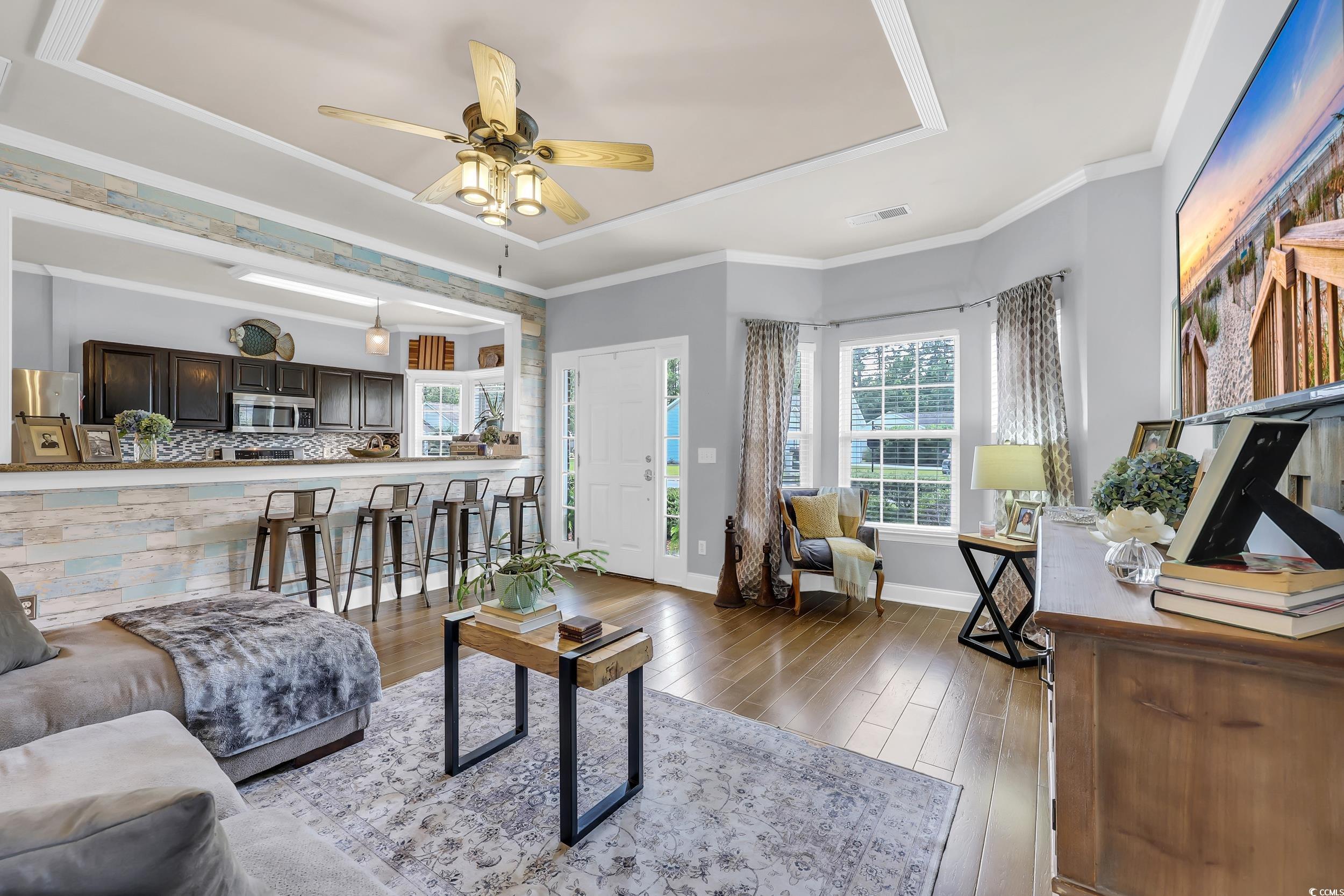 4536 Fringetree Drive Murrells Inlet, SC 29576 - Photo 8 of 40 Living area with a raised ceiling, healthy amount of natural light, wood-type flooring, ceiling fan, and ornamental molding