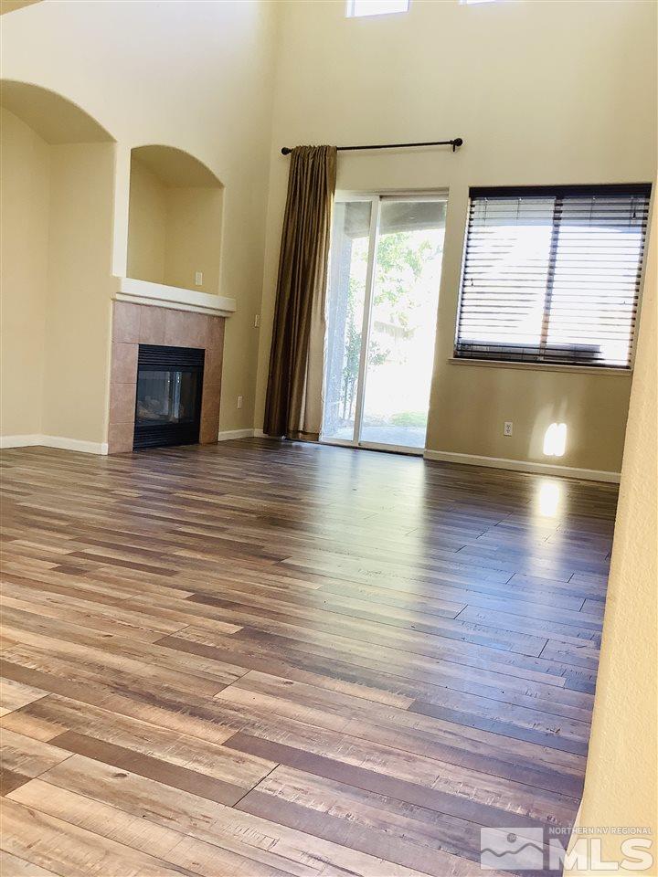9375 Hummer Court Reno, NV 89521 - Photo 13 of 23 an empty room with wooden floor and fireplace