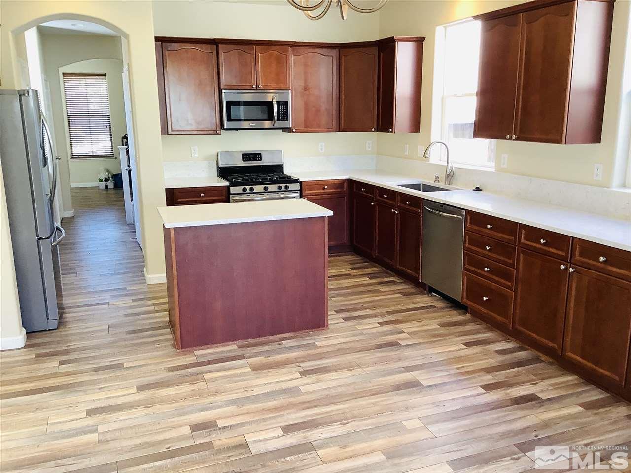 9375 Hummer Court Reno, NV 89521 - Photo 2 of 23 a kitchen with stainless steel appliances granite countertop a stove a sink dishwasher and a microwave oven with wooden cabinets