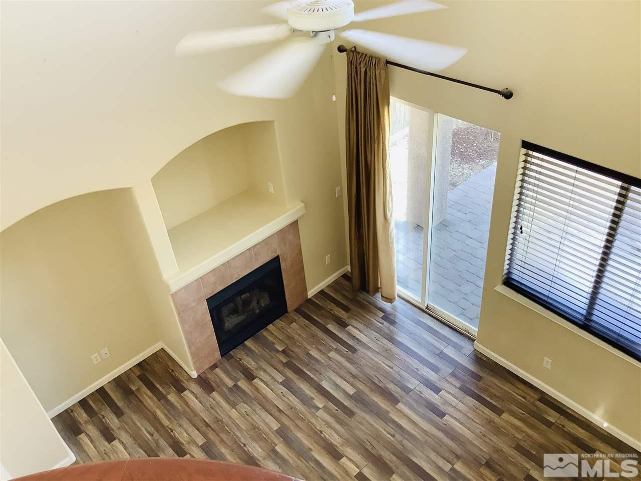 9375 Hummer Court Reno, NV 89521 - Photo 22 of 23 a view of an empty room with wooden floor and a fireplace