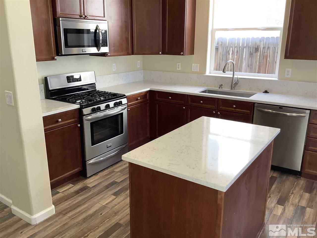 9375 Hummer Court Reno, NV 89521 - Photo 3 of 23 a kitchen with a sink and a stove top oven