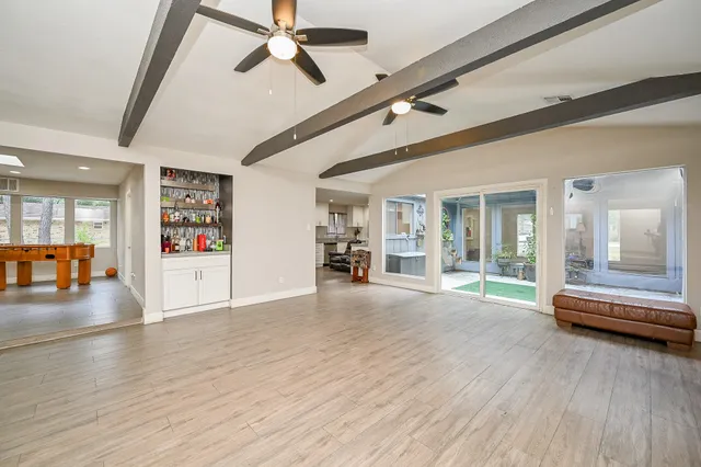 a view of a livingroom with wooden floor and a ceiling fan