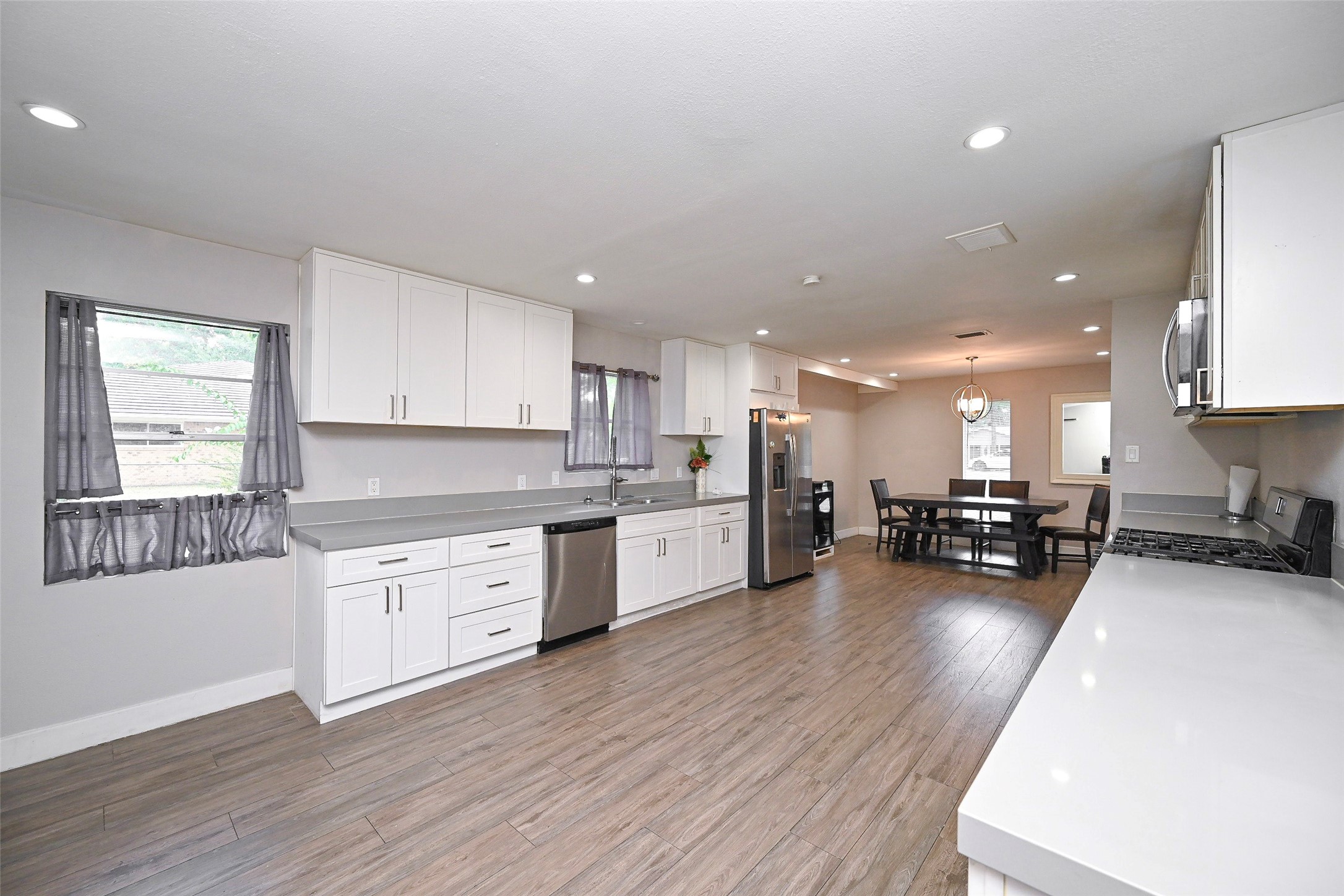 2406 Encreek Road Houston, TX 77068 - Photo 13 of 25 a kitchen with stainless steel appliances granite countertop wooden cabinets a sink a stove a dining table and chairs
